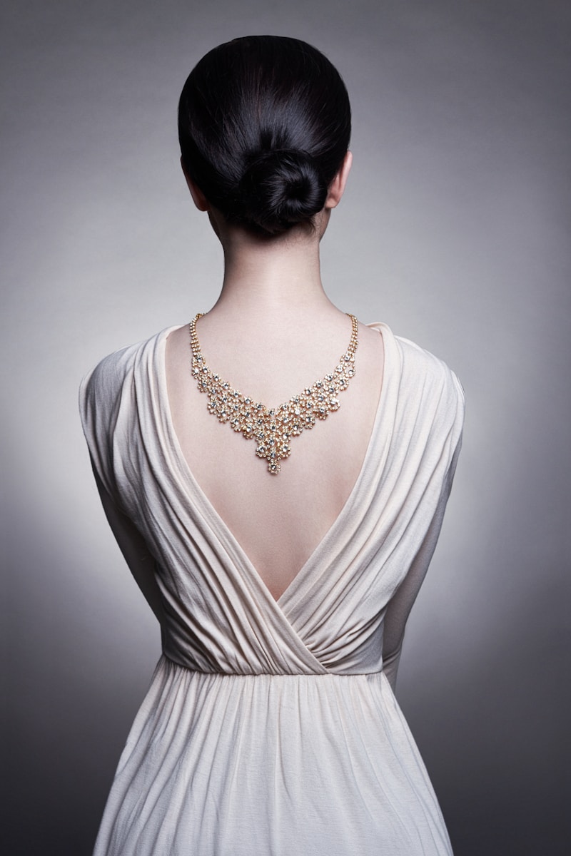 A woman in a white dress with a necklace on her neck